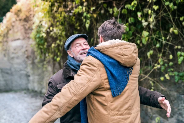 Senior father and his young son on a walk, hugging. — Stock Photo, Image