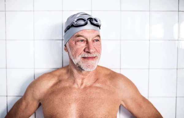 Portrait of a senior man in an indoor swimming pool. — Stock Photo, Image