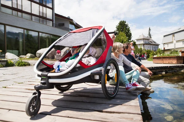 Seniorenpaar mit Enkeln im Joggingwagen. — Stockfoto