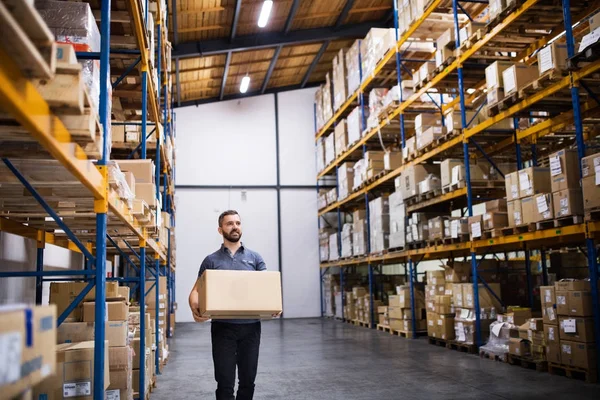 Mannelijke magazijnmedewerker met een grote doos. — Stockfoto