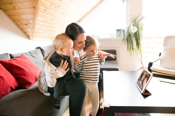 Young family with tablet chatting with their father. — Stock Photo, Image