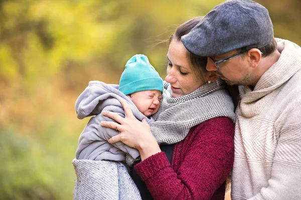 Mooie jonge gezin op een wandeling in de herfst bos. — Stockfoto