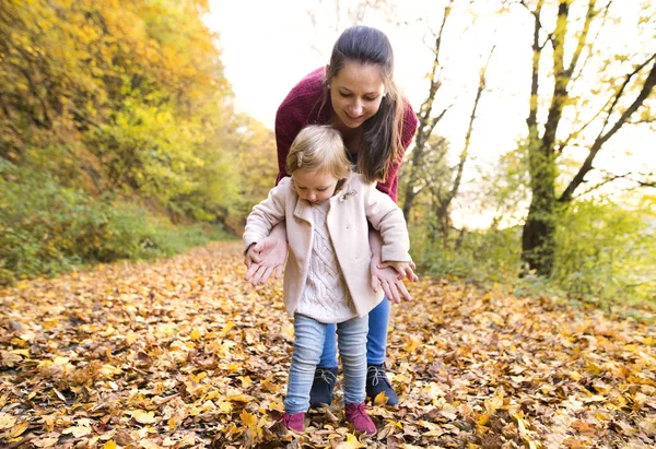 Moeder en dochter op een wandeling in de herfst bos. — Stockfoto