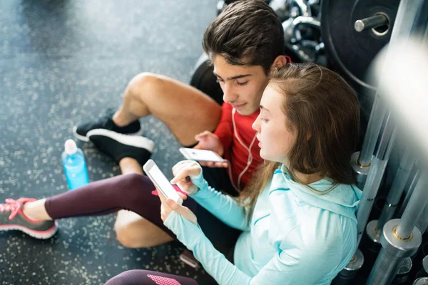 Fit casal no moderno ginásio crossfit com smartphone . — Fotografia de Stock