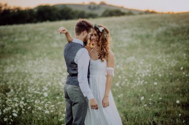 Güzel gelin ve damat yeşil doğa gün batımında.