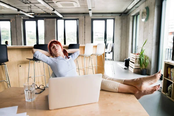 Affärskvinna med laptop i hennes kontor. — Stockfoto