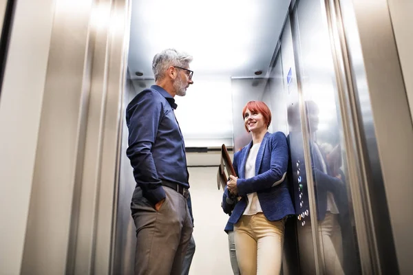 Empresários no elevador no edifício de escritórios moderno . — Fotografia de Stock