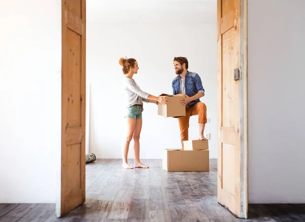 年轻夫妇搬进新房子，抱着箱子. — 图库照片