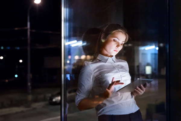 Zakenvrouw met tablet werkt 's avonds laat. — Stockfoto