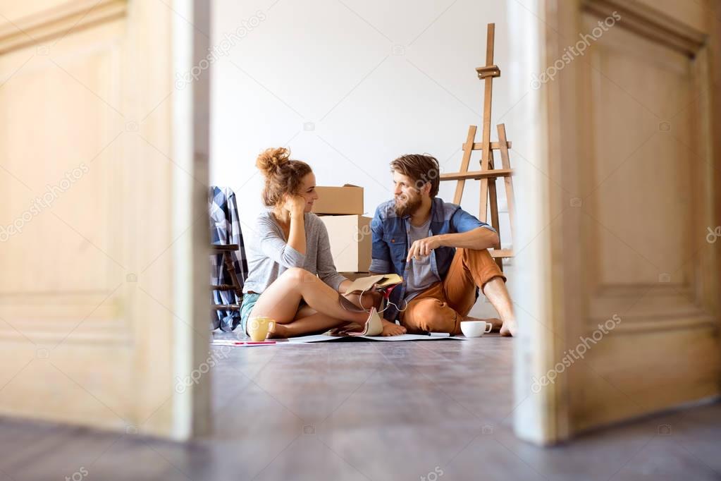 Young couple moving in new house, resting.