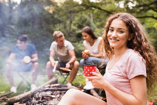 Tieners kamperen, koken van vlees op vreugdevuur. — Stockfoto