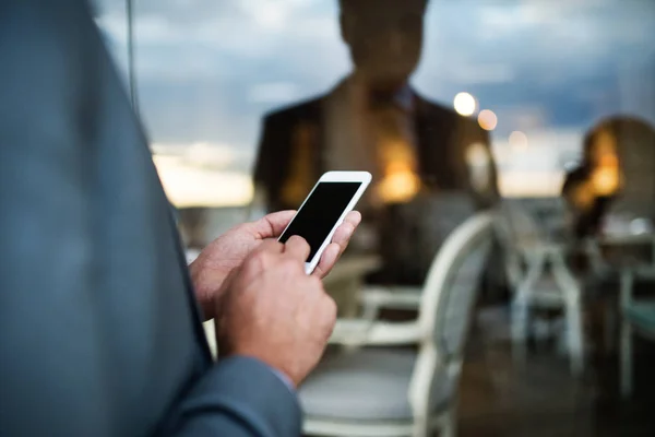 Uomo d'affari con smartphone in un bar all'aperto dell'hotel . — Foto Stock