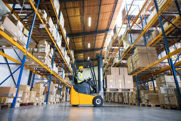 Trabajador de almacén con carretilla elevadora. — Foto de Stock