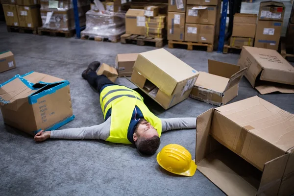 Magazijnmedewerker na een ongeval in een magazijn. — Stockfoto