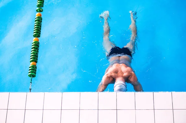 Homme âgé dans une piscine intérieure . — Photo