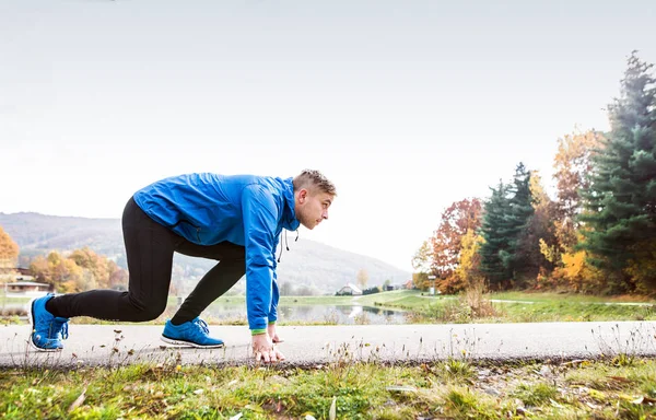 Corridore al lago su sentiero asfaltato in posizione costante . — Foto Stock