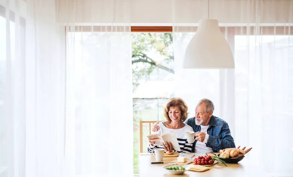 Äldre par äter frukost hemma. — Stockfoto