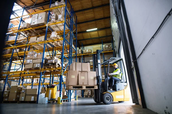 Trabajador de almacén con carretilla elevadora. — Foto de Stock