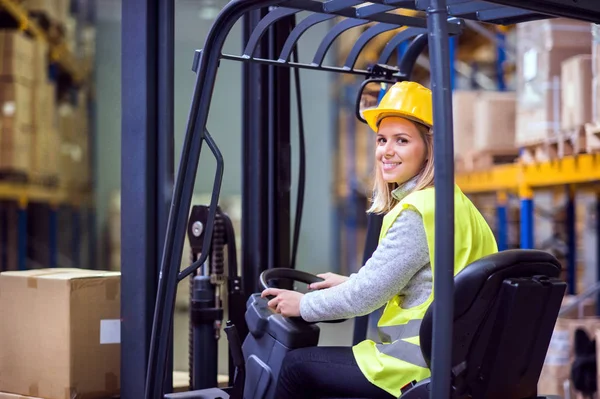 Trabajadora de almacén con carretilla elevadora . — Foto de Stock