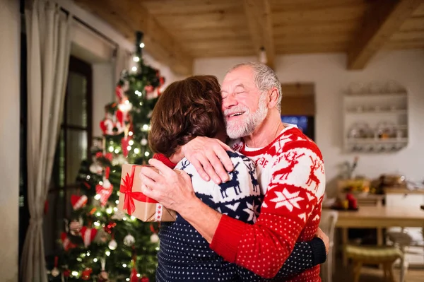 Senior couple exchanging presents at Christmas time. — Stock Photo, Image