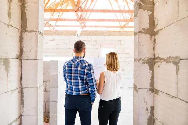 Young couple at the construction site. — Stock Photo, Image