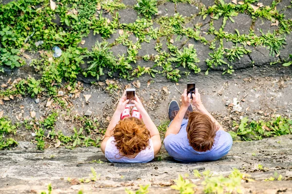 Unga par med smartphones i stan. — Stockfoto