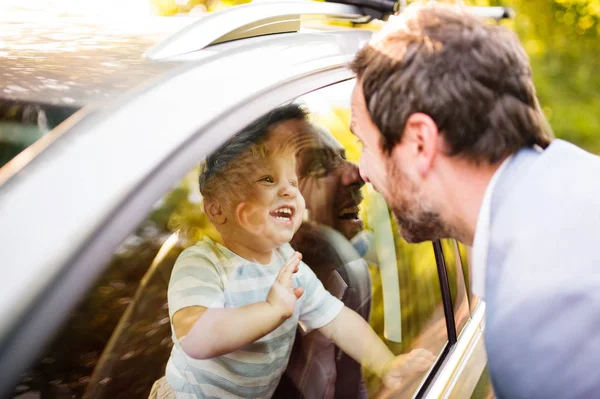 Liten pojke i bilen tittar på sin far. — Stockfoto