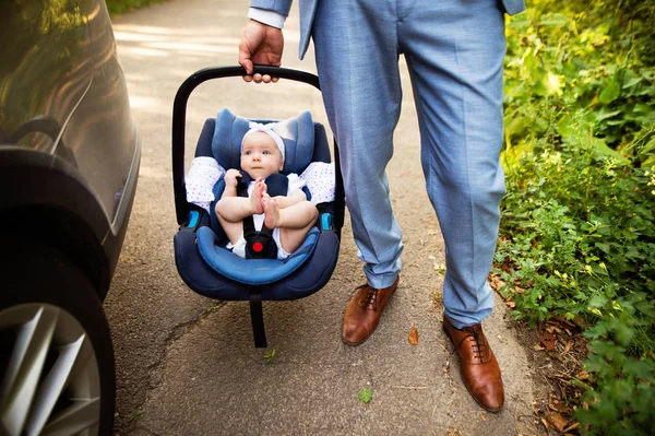 Unbekannter Mann trägt sein kleines Mädchen im Autositz. — Stockfoto