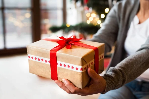 Unrecognizable woman with present at Christmas time. — Stock Photo, Image