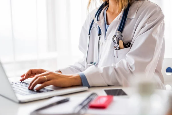 Médica com laptop trabalhando na mesa do escritório . — Fotografia de Stock