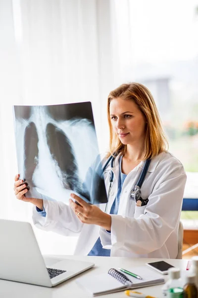 Doctora con rayos X, trabajando en el escritorio de la oficina . — Foto de Stock