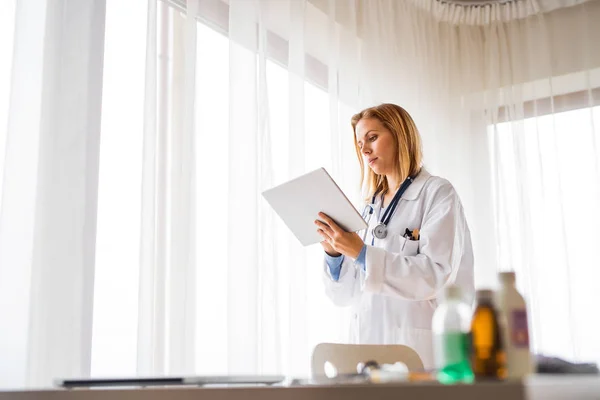 Médico femenino con tableta trabajando en el consultorio . —  Fotos de Stock