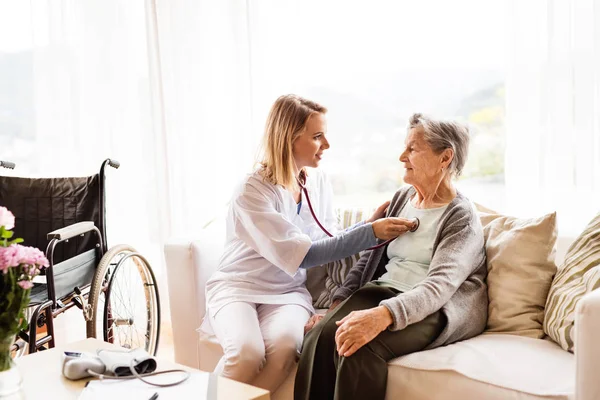 Gesundheitsbesucherin und Seniorin bei Hausbesuch. — Stockfoto