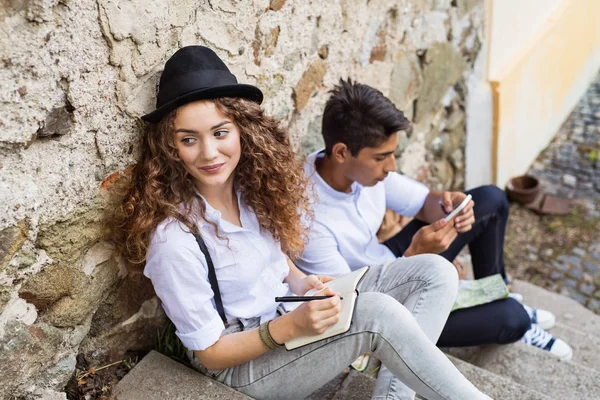 Två unga turister med smartphone i gamla stan. — Stockfoto