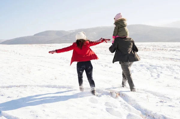 Vader en moeder met hun dochter op een vrije loop, winter natuur. — Stockfoto