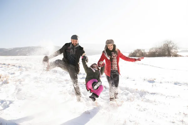 Padre y madre con su hija en un paseo, naturaleza invernal . — Foto de Stock