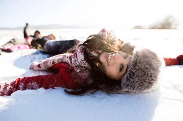 Mulher bonita com a família, se divertindo na neve . — Fotografia de Stock