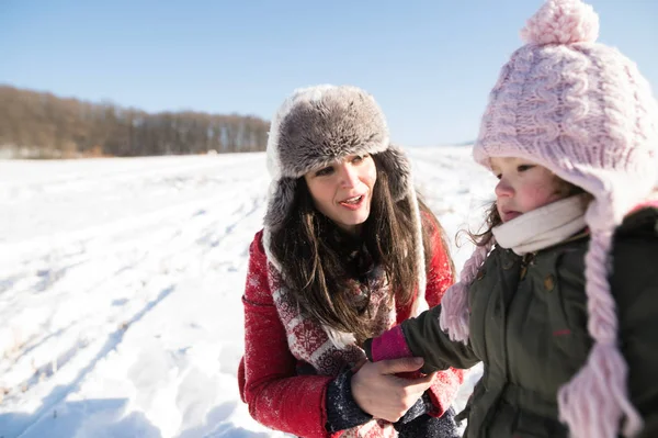 Mamma med hennes dotter, leker i snön. — Stockfoto