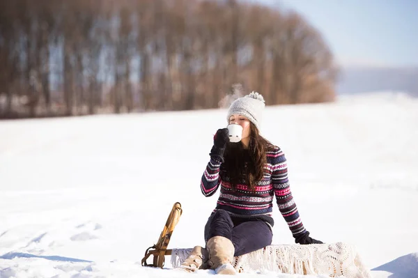 Beautiful young woman with cup of coffee in winter nature — Stock Photo, Image
