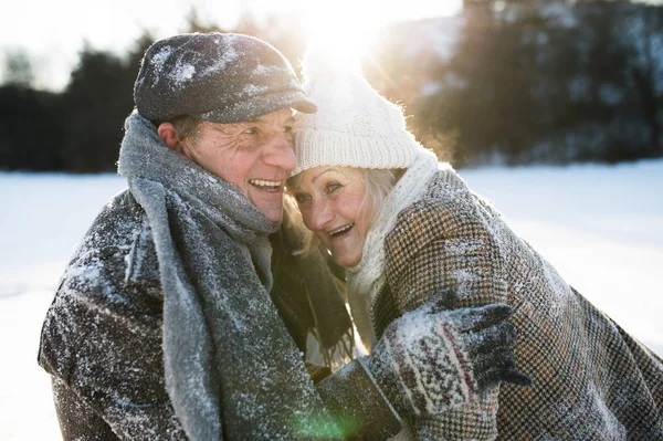 Hermosa pareja de ancianos en un paseo en la naturaleza soleada de invierno — Foto de Stock