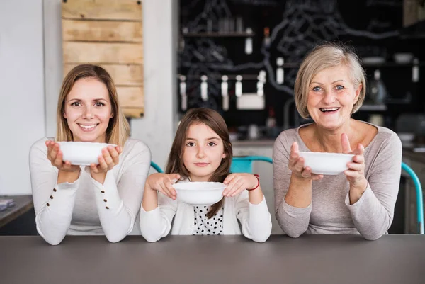 A small girl with mother and grandmother at home. — Stock Photo, Image