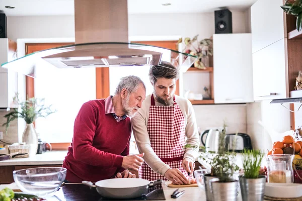 Hipster filho com seu pai sênior cozinhar na cozinha . — Fotografia de Stock