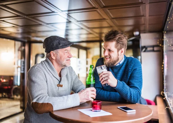 Senior far och hans unge son i en pub. — Stockfoto