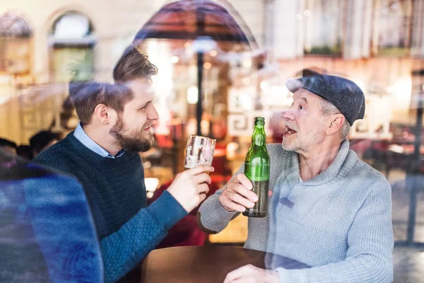 Senior far och hans unge son i en pub. — Stockfoto