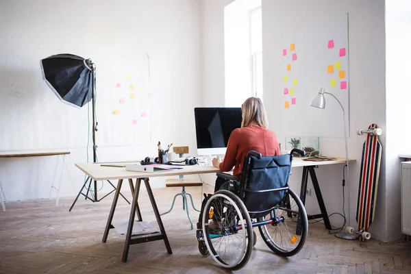 Businesswoman in wheelchair at the desk in her office. — Stock Photo, Image