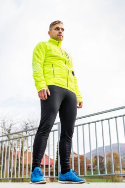 Genç atlet sonbahar park ayakta asfalt yolda.