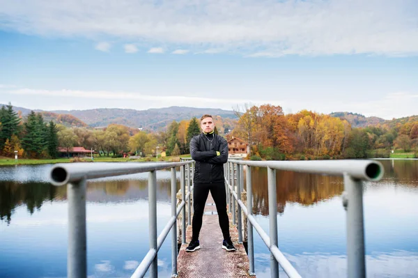 Unga idrottsutövare står på en brygga, armarna korsade. — Stockfoto