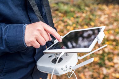 Tablet ve drone denetleyici sonbahar Park olan adam.