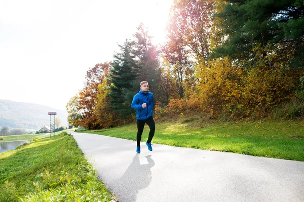 年轻运动员在公园里奔跑在多彩的秋天自然. — 图库照片