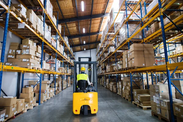 Trabajador de almacén con carretilla elevadora. — Foto de Stock